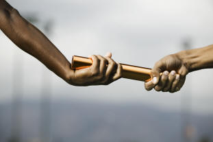 two hands passing a baton