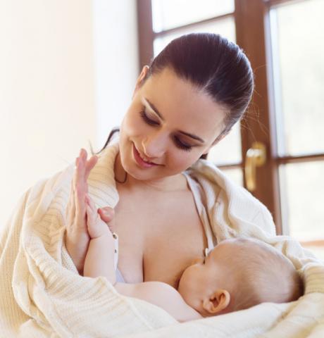 Woman Breastfeeding a Baby Wrapped in a Blanket